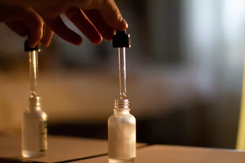 Massage oil being drawn into a glass dropper